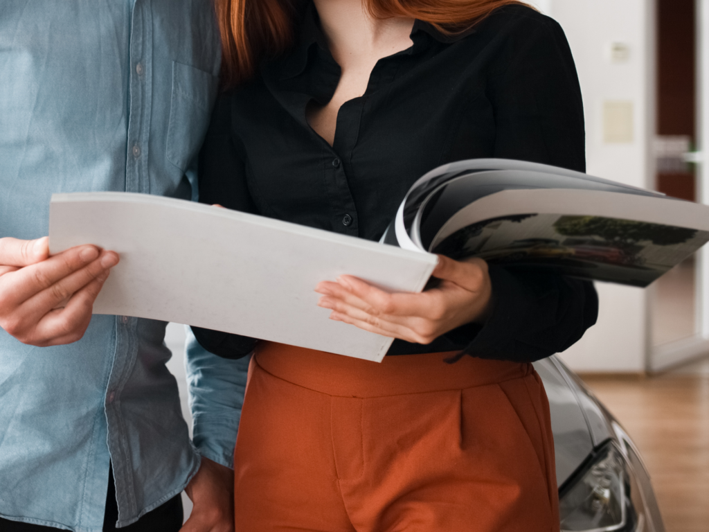 Coppia di clienti che valuta un acquisto consultando una brochure informativa.