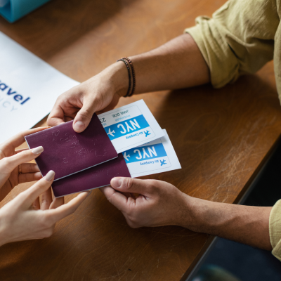 Agente di viaggi che consegna passaporto e biglietti aerei a un cliente.