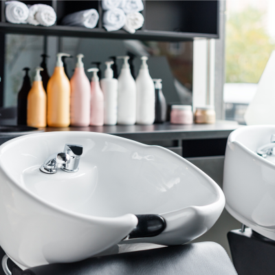 Interno del salone [Nome Salone] con lavatesta moderni e prodotti professionali.